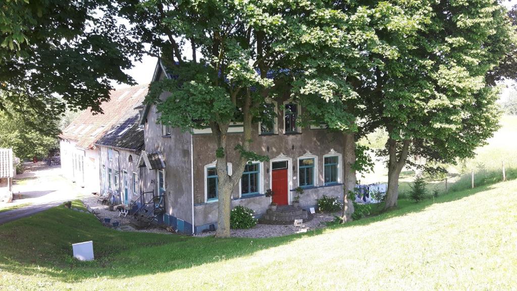 莱克凯尔克Theetuin Onder de Pannen的院子里有红色门的老房子