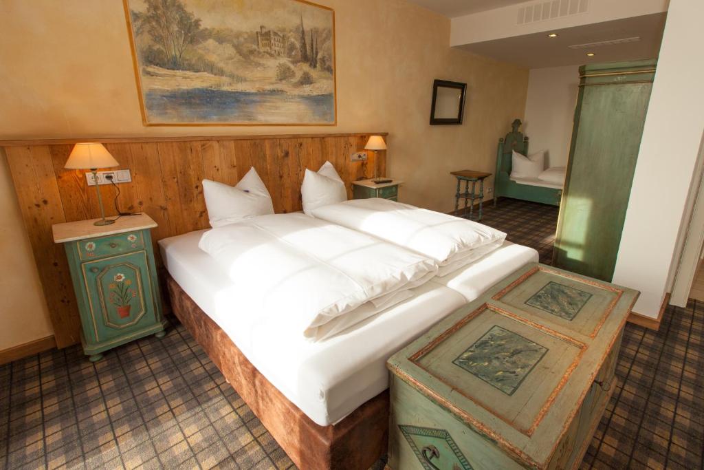 施坦贝尔格湖畔贝格奥夫基辛POST酒店的一间带白色大床的卧室和一间浴室
