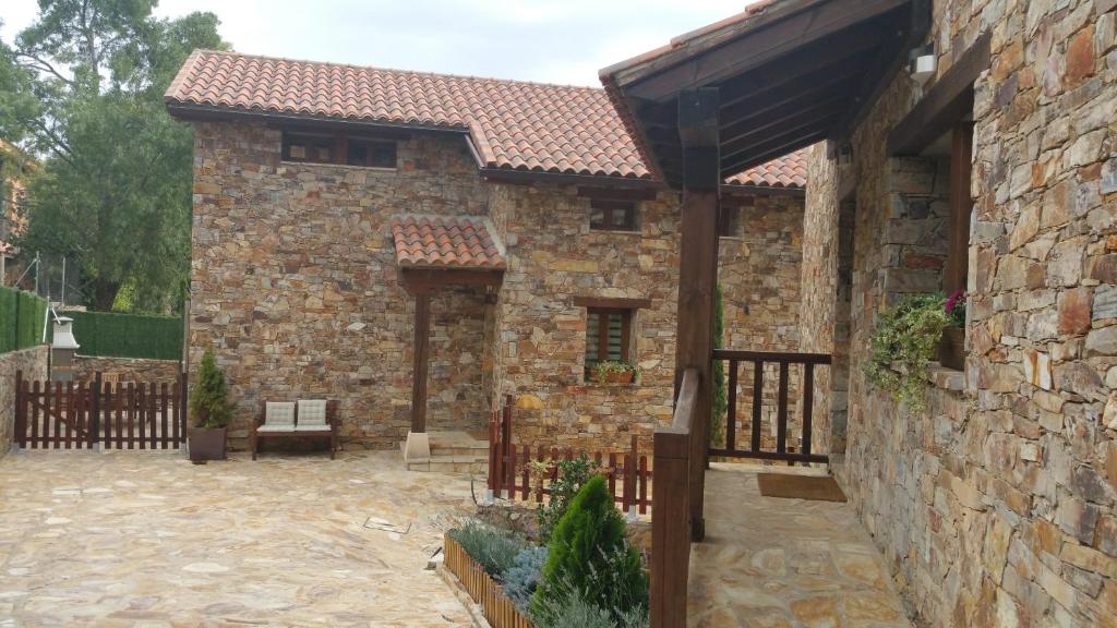 Berzosa del LozoyaNature Rural的石头房子,设有木栅栏和庭院