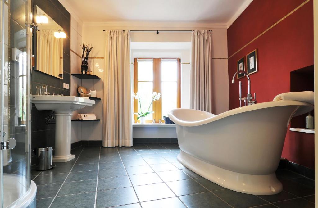罗滕堡赫尼施洛斯臣酒店的一间带大浴缸和水槽的浴室