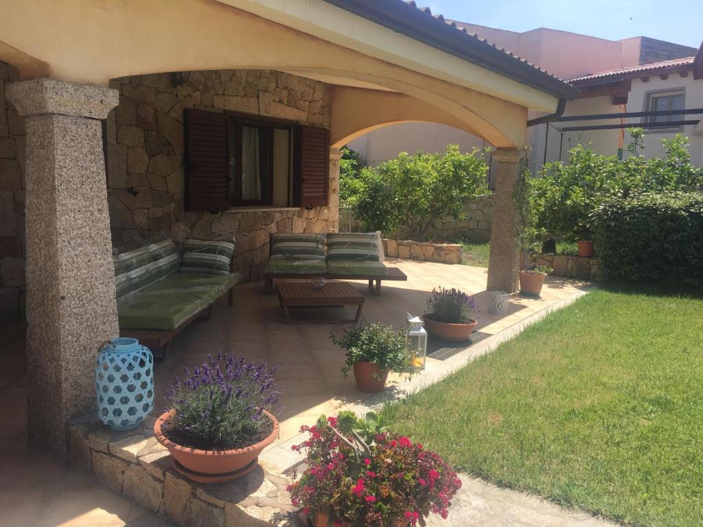 布多尼Sa Murta Bianca Guesthouse的庭院里种有长椅和盆栽植物