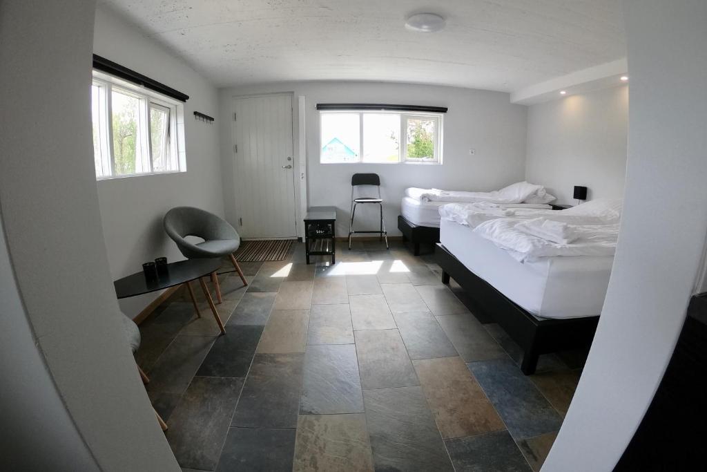 伊纳斯塔蒂Hamrar的一间卧室配有两张床、一张桌子和两个窗户。