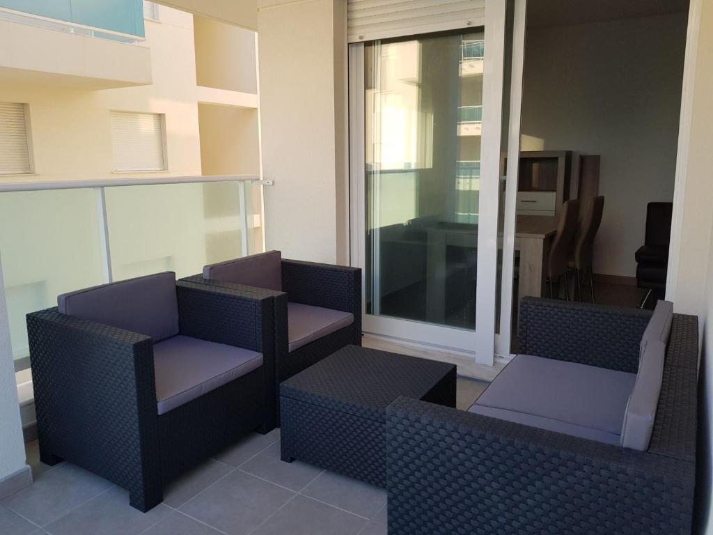 皮莱斯Apartamento playa Piles的阳台配有两把椅子和窗户。
