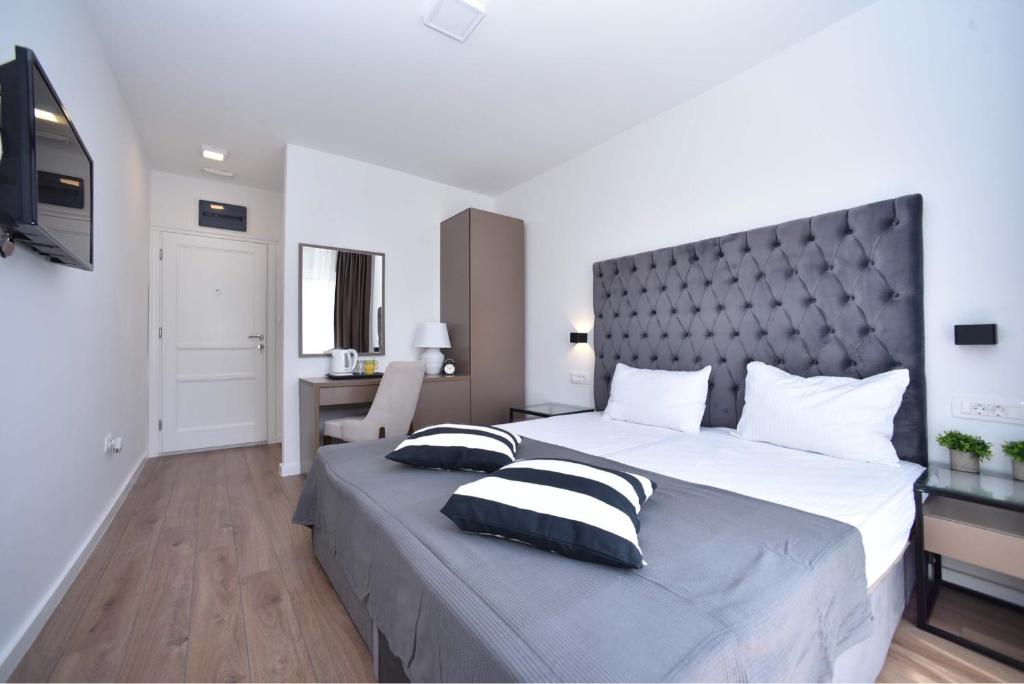 布德瓦Apartments 110 in Budva的一间卧室配有一张大床和两个枕头