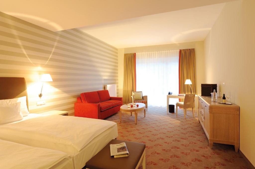 巴特诺因阿尔-阿尔韦勒桑可特皮特兰德酒店的酒店客房,配有一张床和一张红色椅子