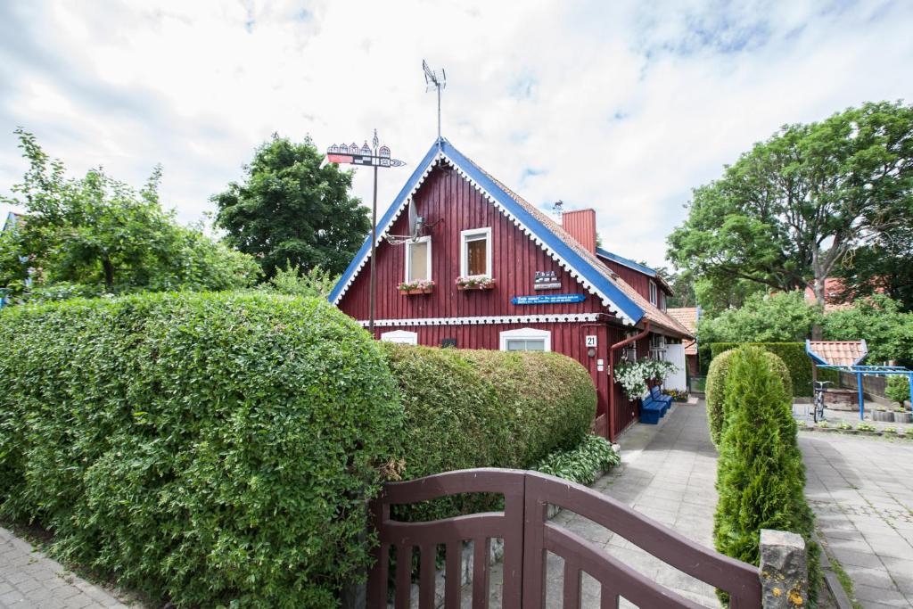 奈达Žvejo namas的蓝色屋顶和长凳的红色房子