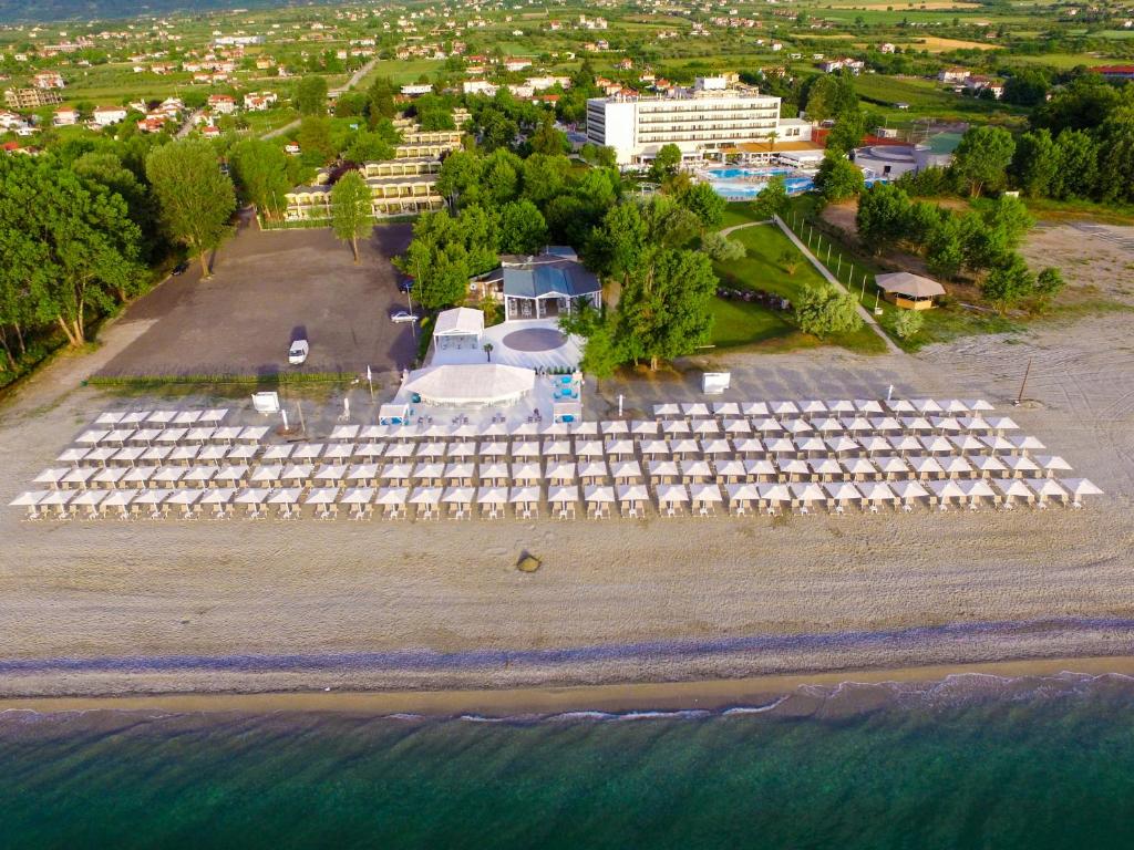 乐托卡亚Olympian Bay Grand Resort的享有海滩的空中景致,配有白色遮阳伞