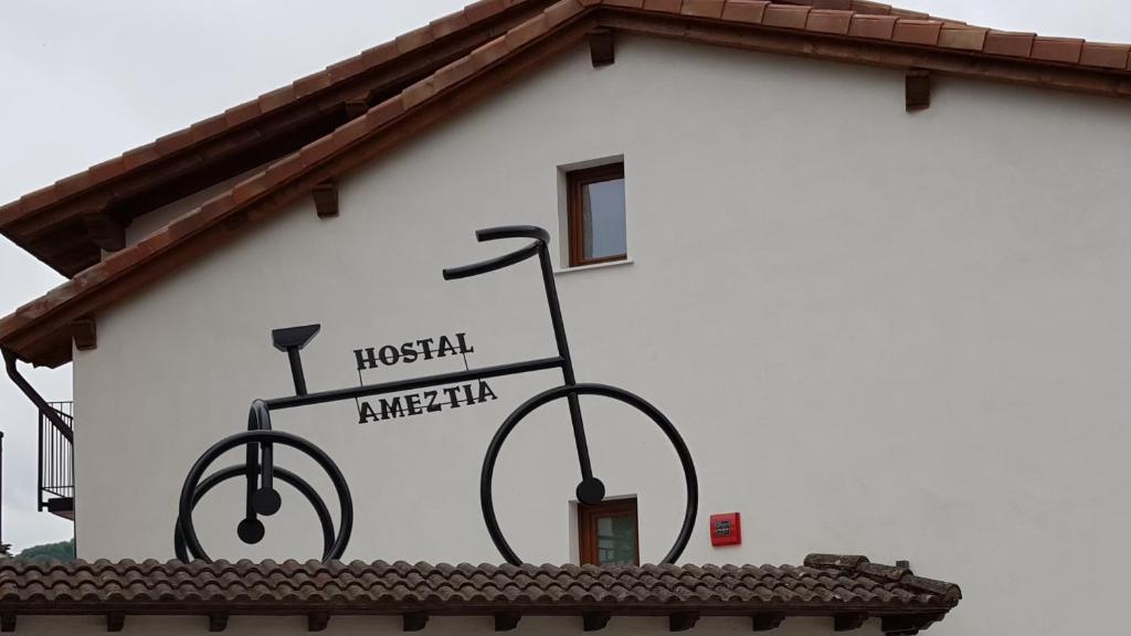 Doneztebe阿美希亚旅馆的建筑物边的标志,上面有一辆自行车