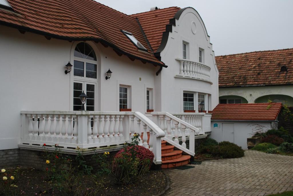 Sarród罗扎利亚温德哈兹旅馆的白色的房子,设有门廊和阳台