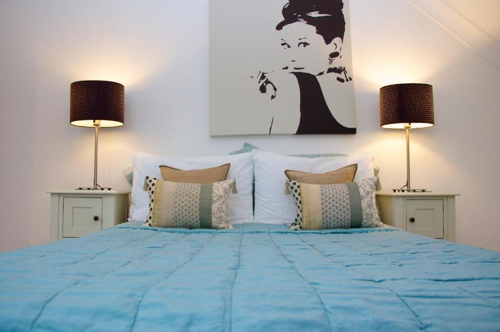 考斯一五零酒店的一间卧室配有一张带两盏灯的蓝色床。