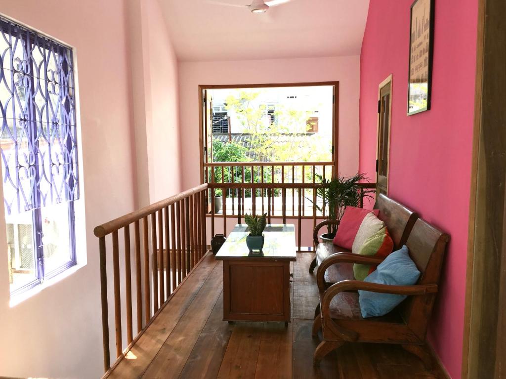 归仁The Bohome的客厅设有粉红色的墙壁和椅子