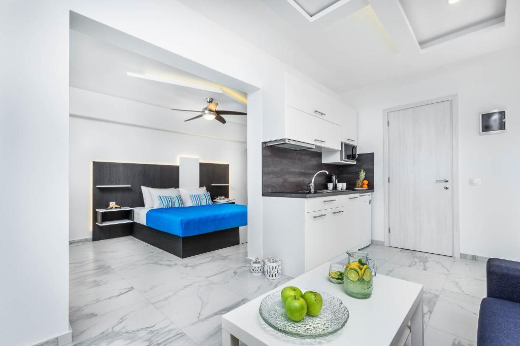 佩科霍里Asterias Premium Holiday Apartments的厨房以及带蓝色沙发的起居室。