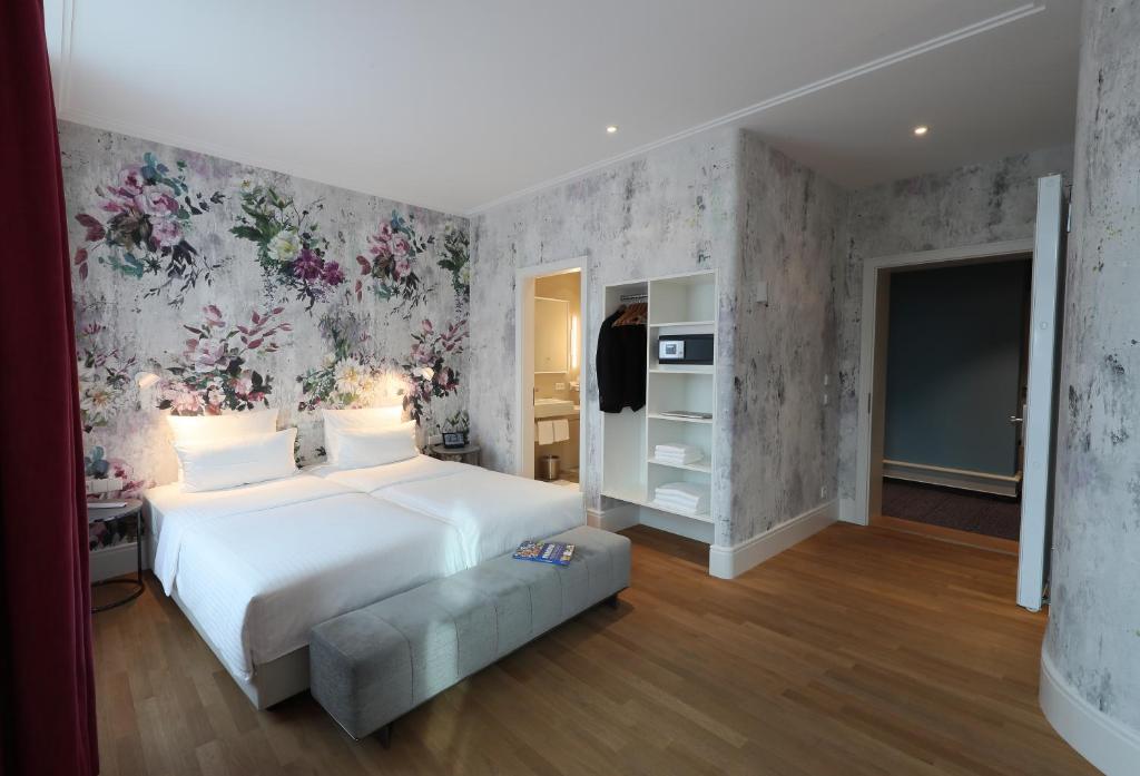 慕尼黑MOMA1890 Boutique Hotel的卧室配有一张白色大床和花卉壁纸