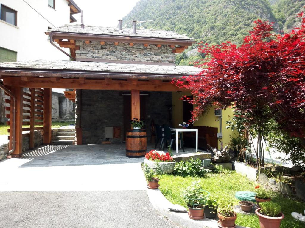 ChampdeprazAcero Rosso的石头建筑,带花卉和植物的门廊