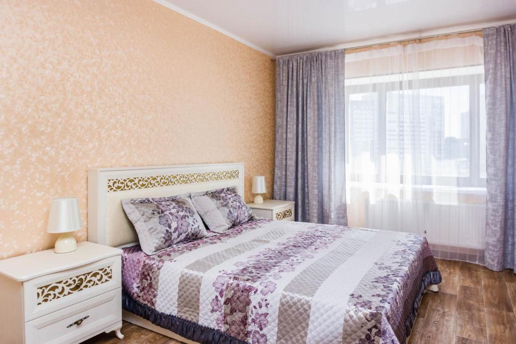 秋明Apartment on Kharkovskaya 66的一间卧室设有一张床和一个窗口