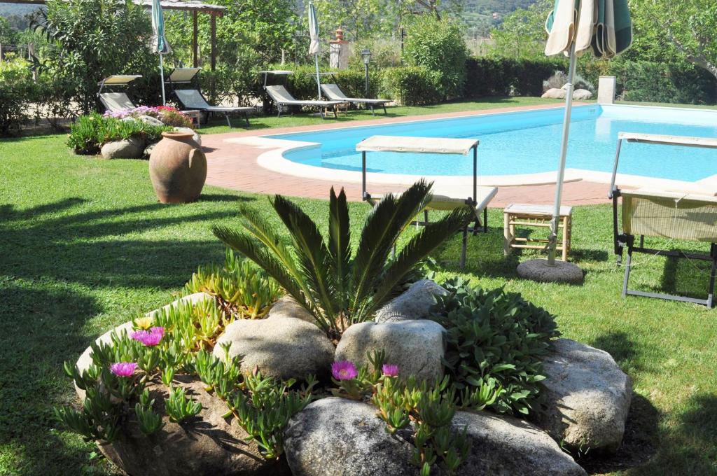 费拉约港Hotel Tirrena Bike & Country Hotel的一个带岩石和游泳池的花园