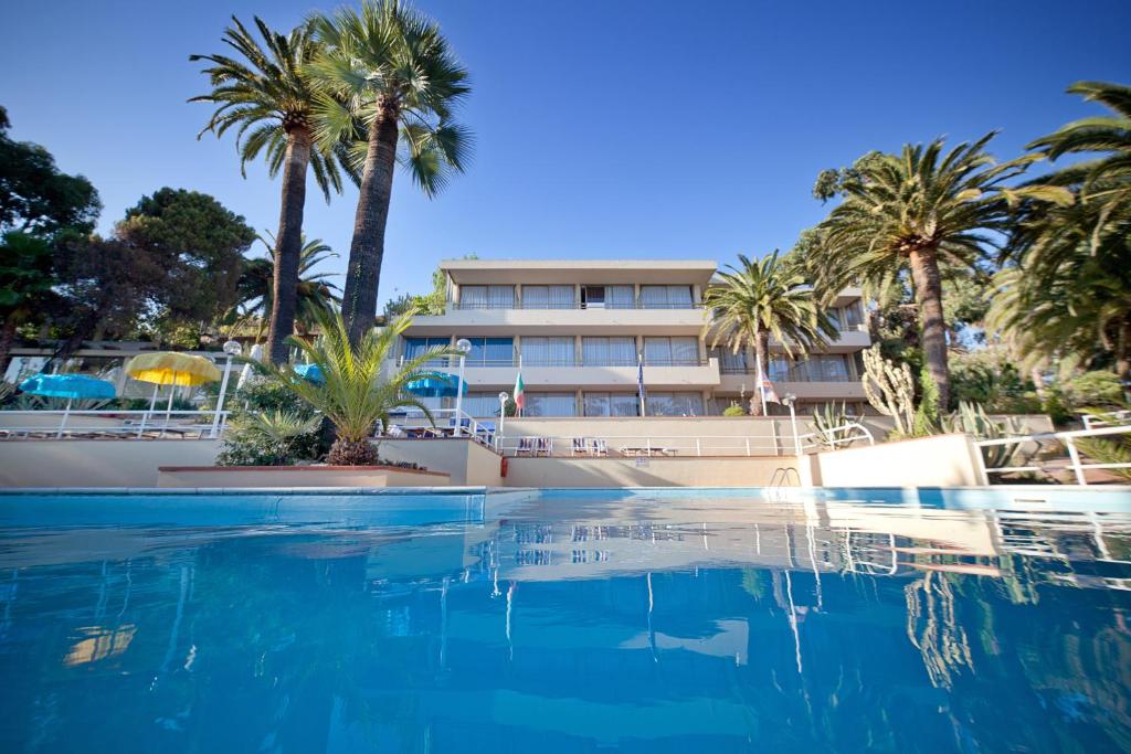 圣雷莫尼亚拉套房酒店的一座棕榈树游泳池和一座建筑