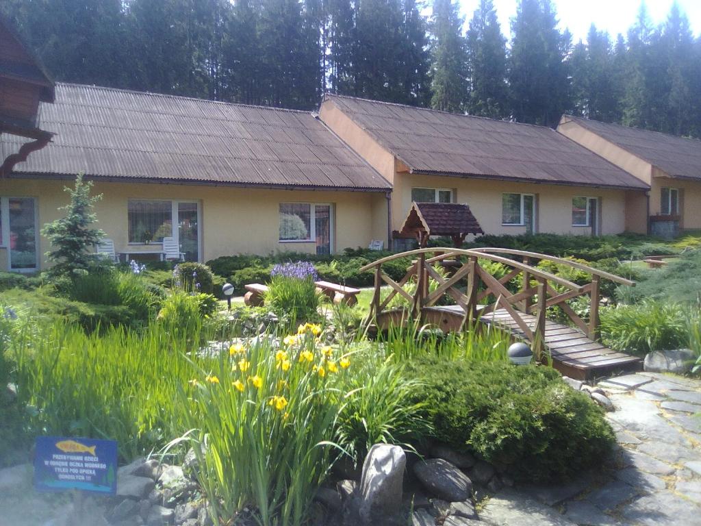 拉伊恰Ośrodek Wczasowy "GRONOSTAJ"的花园前有木桥的房子