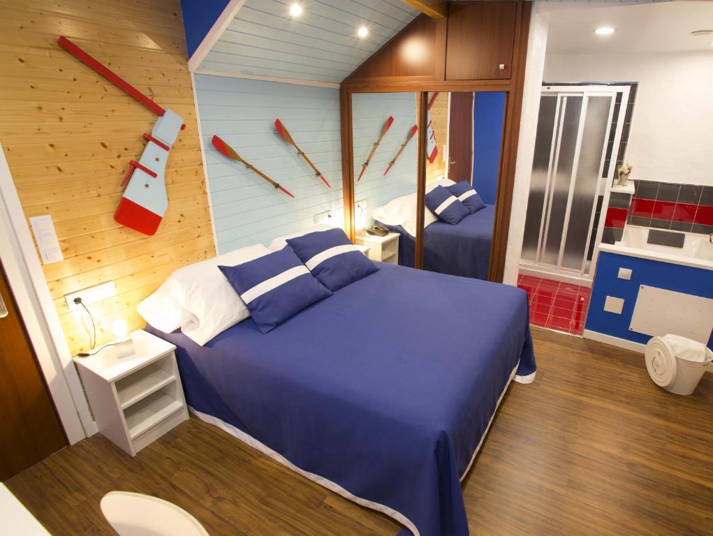 里瓦德奥Hotel A. G. Porcillan的一间卧室配有一张蓝色的床和墙上的时钟