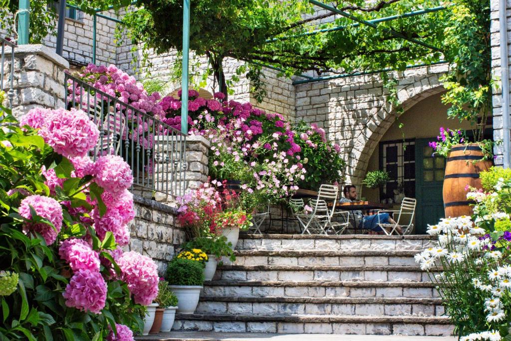 阿里斯蒂兹西斯旅馆的一座种有粉红色花卉的花园,一个坐在桌子上的人