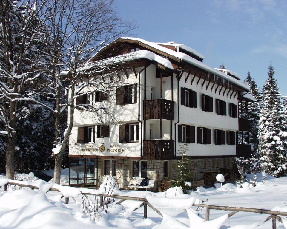 波罗维茨Victoria Hotel Borovets - Free Parking的雪中积雪覆盖的房子