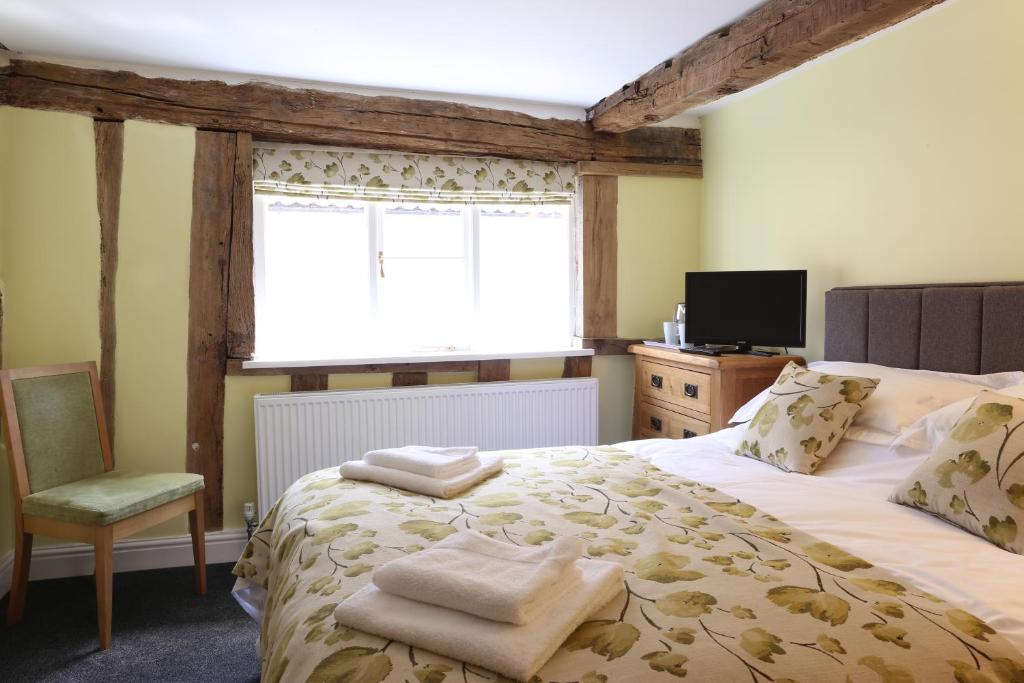New BuckenhamThe Kings Head的一间卧室设有一张大床和一个窗户。