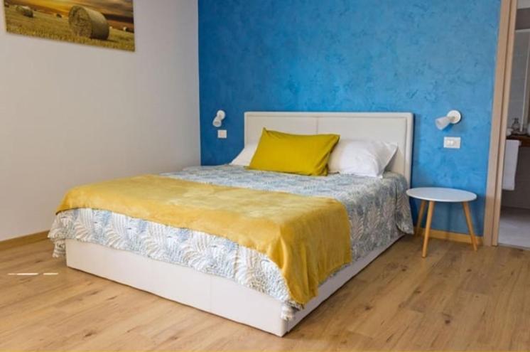 阿罗纳Il Gatto Stanco B&B的一间卧室配有一张带黄色枕头和桌子的床