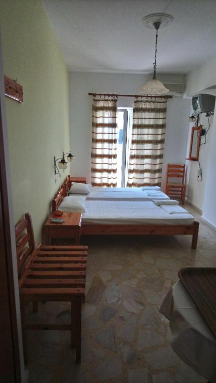 毕达哥利翁卡尔里罗瑞一室公寓的一间卧室设有一张大床和两个窗户。