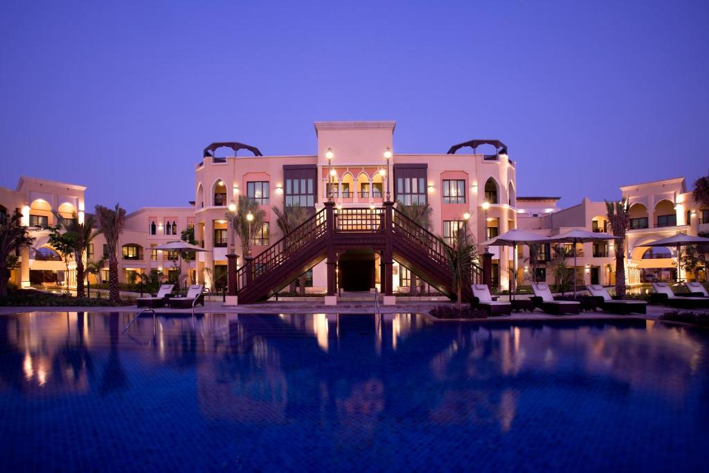 阿布扎比Shangri-La Hotel Apartments Qaryat Al Beri的大楼前的大型游泳池