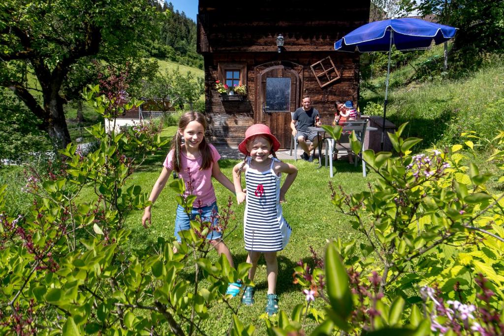 穆劳Chalet "Knusperhäuschen"的两个小女孩在院子里散步