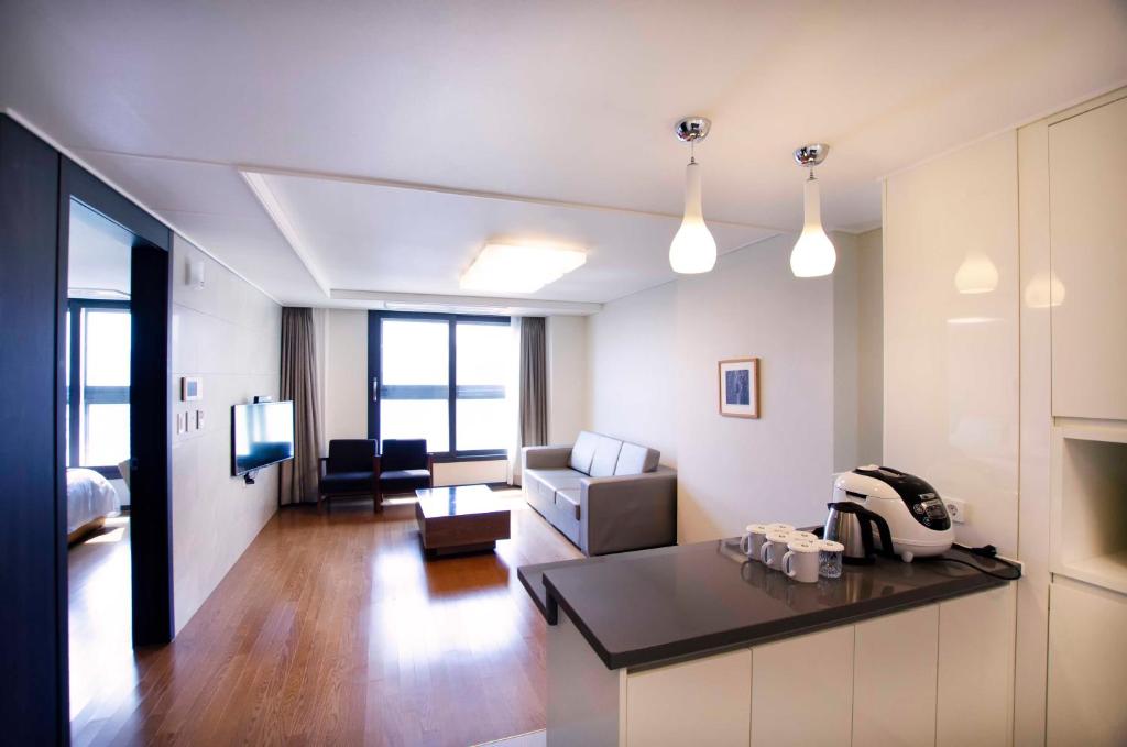 釜山普利布兰科酒店公寓的一个带厨房的大客厅和一间客厅