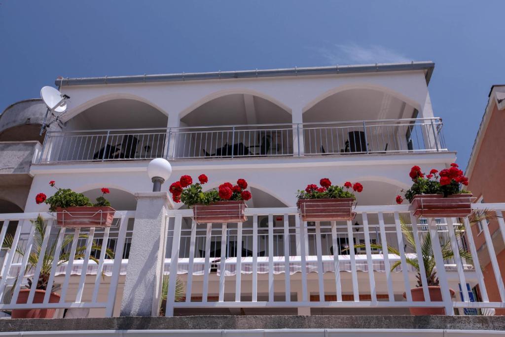 格拉达茨Apartments Ursula的阳台上的白色房子,有红色的鲜花