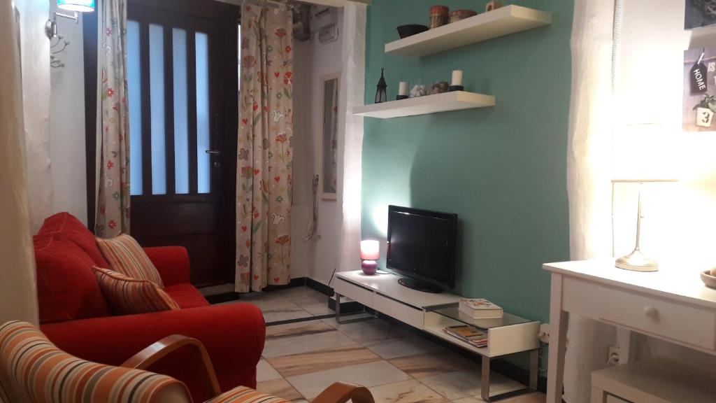 卡韦苏埃拉德尔瓦列La casita del jerte的一间带电视和红色沙发的客厅