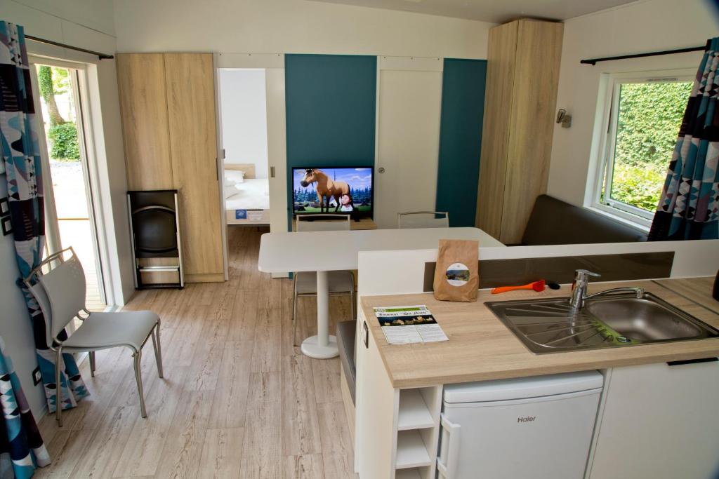 迪尔巴克Tornade的客房设有带桌子和电视的厨房。