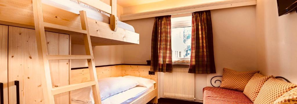 塞尔瓦迪加尔代纳山谷巡回酒店的客房设有两张双层床和一扇窗户。