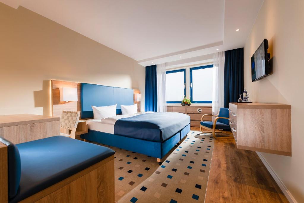 奥斯特西巴德钦诺维茨Baltic Zinnowitz - Hotel mit Meerwasserpool und Thermalbad的配有一张床和一张书桌的酒店客房