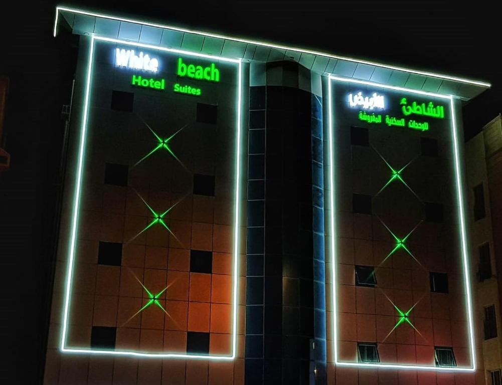 拉比格White Beach Hotel Suites的建筑的侧面有 ⁇ 虹灯标志