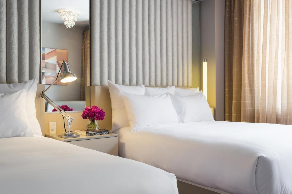 达拉姆达勒姆21C博物馆酒店的配有白色枕头的酒店客房内的两张床