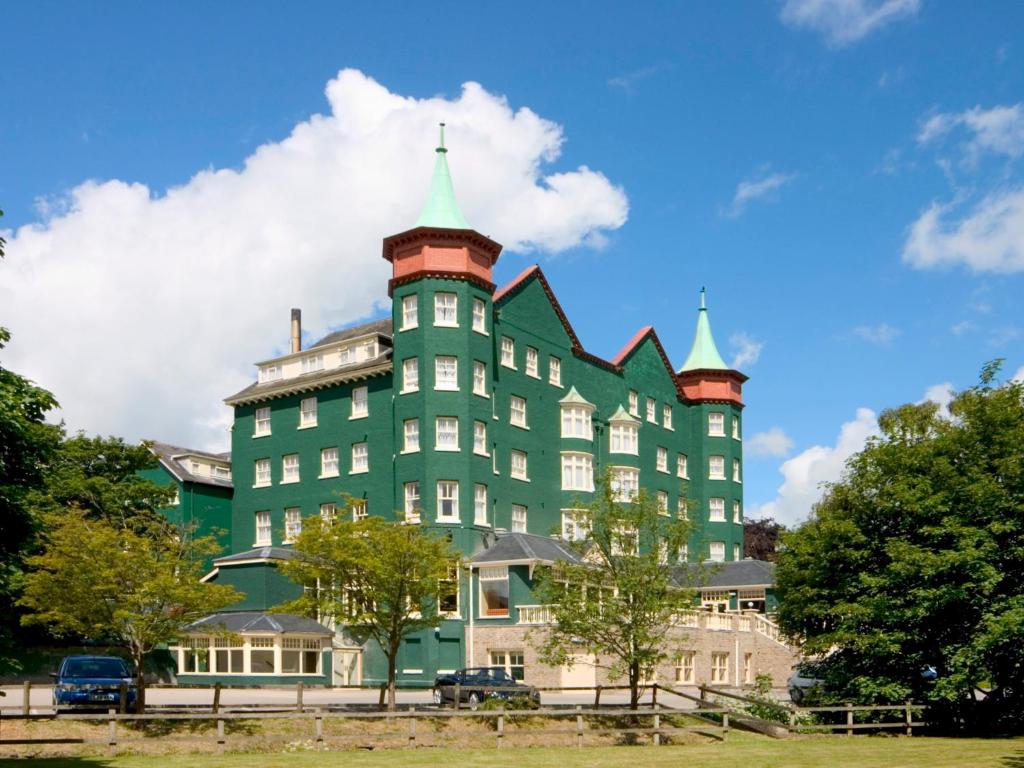 兰德林多德威尔斯大都会Spa酒店的一座绿色的大建筑,上面有两座塔楼