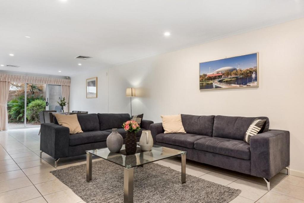 阿德莱德Adelaide Style Accommodation-Close to City-North Adelaide-3 Bdrm-free Parking的客厅配有两张沙发和一张桌子