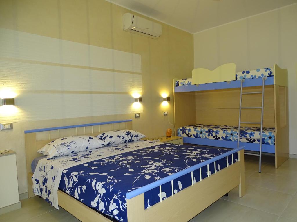 费尔莱恩Linda Casa Vacanze的一间卧室配有两张带蓝白色床单的床