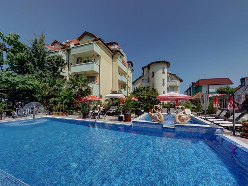 辛尼莫雷特Family Hotel Gogov的一座带椅子和遮阳伞的游泳池位于一座建筑旁边