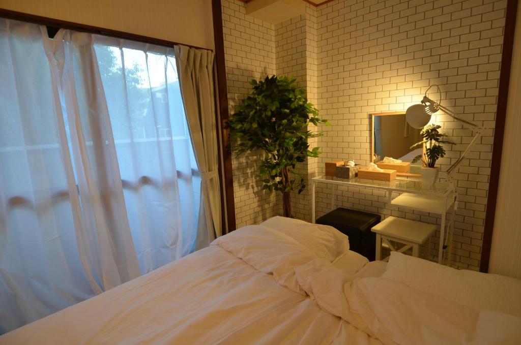 别府Comfort CUBE PHOENIX Beppu (やよいビル)的卧室配有白色的床和镜子