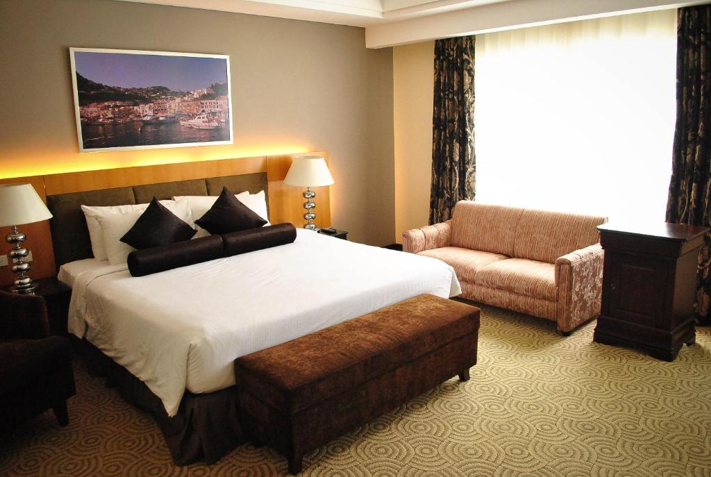 宿务伊丽莎白酒店 的酒店客房带一张大床和一把椅子