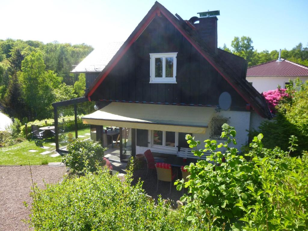 孙登Panoramaferienhaus Sorpesee的一间黑色屋顶的小房子