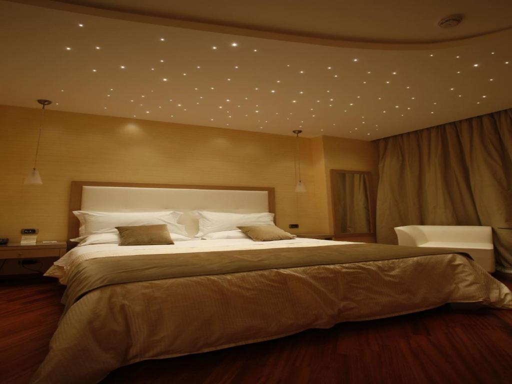 陶尔米纳依斯佩利亚别墅酒店的大卧室配有一张带白色枕头的大床