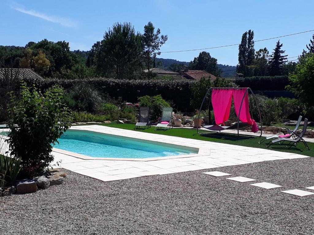 图雷特La Colombe的花园内的游泳池,带粉红色窗帘