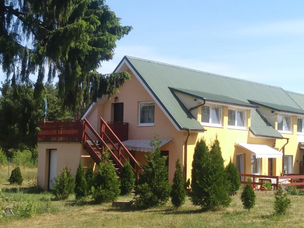 WąglikowiceAgroturystyka Zielona Polana的黄色的绿色屋顶房屋