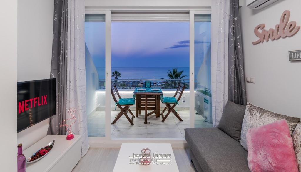 多列毛利诺斯Roca Chica A. Apartamento 211的客厅配有桌椅,享有海景。