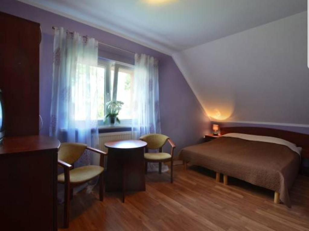 波别罗沃Janina的卧室配有一张床和一张桌子及椅子